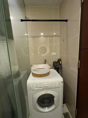 a washing machine with a basket on top of it at Modern Nordic 1BR Big Queen Bed Uptown BGC in Manila