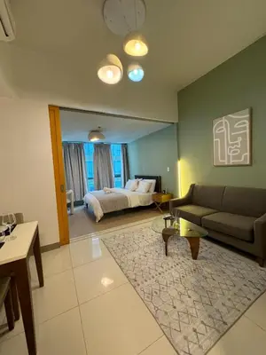 a living room with a bed and a couch at Modern Nordic 1BR Big Queen Bed Uptown BGC in Manila