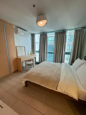 a bedroom with a large bed and a desk at Modern Nordic 1BR Big Queen Bed Uptown BGC in Manila