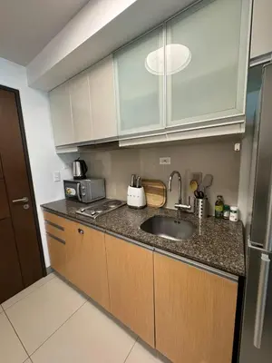 a kitchen with a sink and a refrigerator at Modern Nordic 1BR Big Queen Bed Uptown BGC in Manila