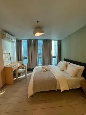 a bedroom with a large bed with a desk and windows at Modern Nordic 1BR Big Queen Bed Uptown BGC in Manila