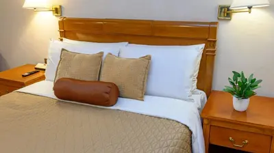 a bedroom with a bed with white sheets and pillows at Ortigas CBD Near Business & Shopping Hubs in Manila