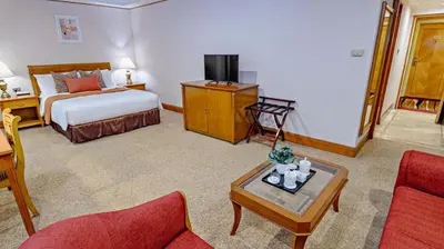 a hotel room with a bed and a coffee table at Ortigas CBD Near Business & Shopping Hubs in Manila
