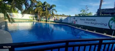 a large swimming pool with blue water and palm trees at Alabang Staycation By Renz in Manila