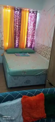 a bed with colorful pillows on top of it at Alabang Staycation By Renz in Manila