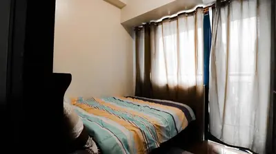 a bedroom with a bed next to a window at Smart Cozy Home Air Residences Makati 4125 in Manila