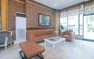 a living room with a couch and a table and chairs at RedDoorz at MPT Suites in Manila