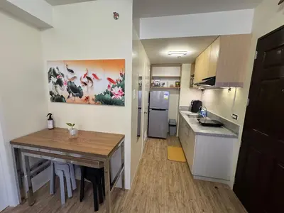 a kitchen with a wooden table and a kitchen with a dining room at Berkeley Suites, Silang Cavite in Silang