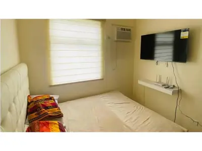 a small room with a bed and a tv at Fully Furnished Condo for Rent in Manila