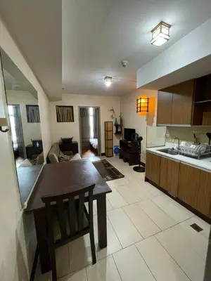 a kitchen and a living room with a table and a counter at Makati City Antel Spa Residences 2707 in Manila