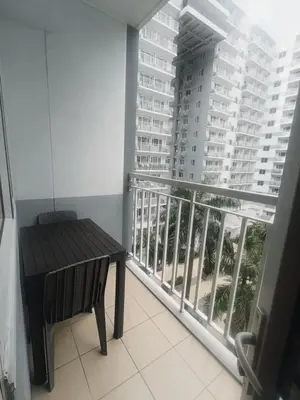 a balcony with a table and a view of a building at Shell Residences in Manila