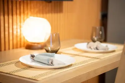 a table with two plates and two wine glasses at Brand New Unit Shell Residences 1BR Near MOA NAIA in Manila