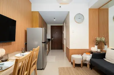 a kitchen and a living room with a refrigerator at Brand New Unit Shell Residences 1BR Near MOA NAIA in Manila