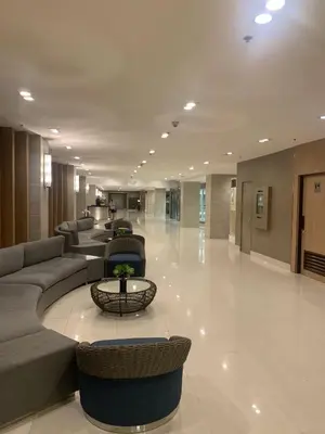 a lobby with couches and chairs in a building at MOA Staycation - by Marites in Manila