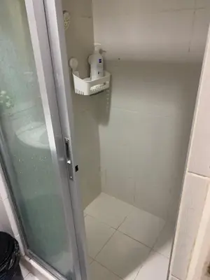 a bathroom with a shower stall with a sink at MOA Staycation - by Marites in Manila