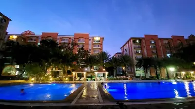 a hotel with two large pools at night at Chateau Elysee A11 near bar resto mall Airport in Manila