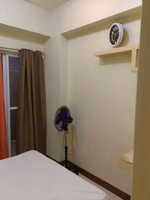 a room with a bed and a clock on the wall at Chateau Elysee A11 near bar resto mall Airport in Manila