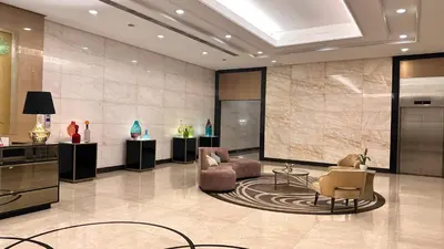 a lobby with two chairs and a large screen at AdahkuMaya Luxury Suites in Manila