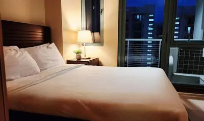 a bedroom with a large white bed and a window at Casa Antonio at 8L Two Palm Tree Beside NAIA3 in Manila