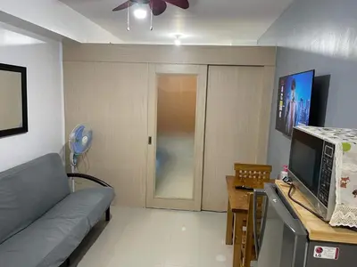 a living room with a couch and a tv at Joyce Condo unit Sea Residences in Manila