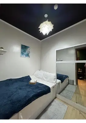 a bedroom with a large bed and a chandelier at Cozy Urban Staycation Condo Unit in Manila