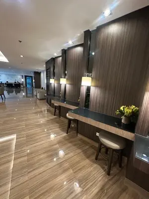 a hotel lobby with a row of tables and chairs at Air Residences 3 by AG in Manila