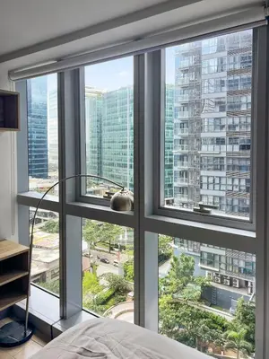 a bedroom with a large window with a view of a city at Modern 1BR BGC Uptown View in Manila