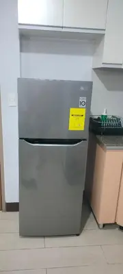 a refrigerator in a kitchen with a yellow sign on it at Bb Drew Rooms Near Airports in Manila
