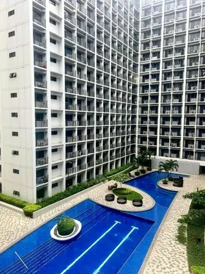 a large building with a swimming pool in front of a building at Stylish 1BR Condo at Shore Netflix & Chill-Pool View in Manila