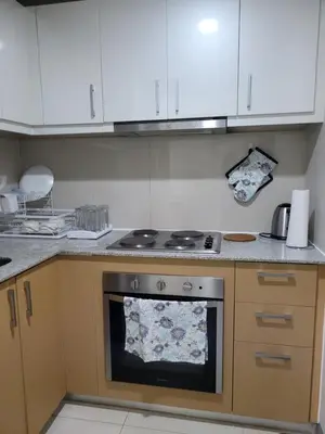 a kitchen with white cabinets and an oven at BGC Uptown Park Suites Tower 1 - 2 Bedroom and 2 Bath Condo in Manila