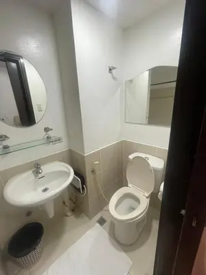 a bathroom with a white toilet and a sink at A venue Residences 1801 in Manila