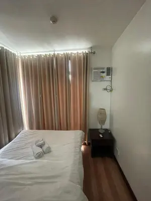 a bedroom with a bed with two towels on it at A venue Residences 1801 in Manila