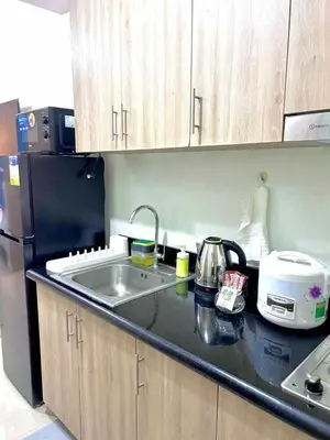 a kitchen counter with a sink and a refrigerator at 1 Bedroom Condo at Shore 2 Near Airport with Balcony & Pool View in Manila