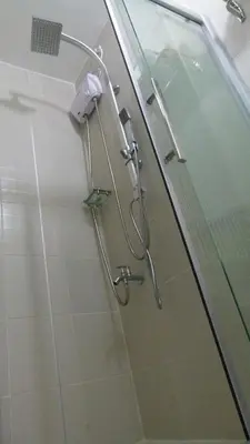 a shower in a bathroom with a glass door at Fully Furnished 1BR Condo at Jazz Residences in Manila