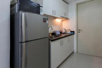 a kitchen with a refrigerator and a sink at Fully Furnished 1BR Condo at Jazz Residences in Manila