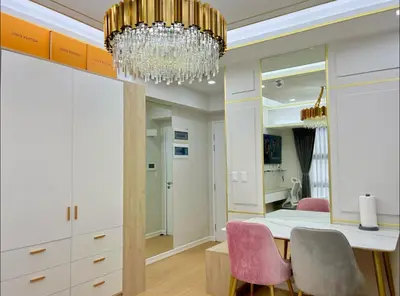 a dining room with a chandelier and pink chairs at Chic BGC Stay - Hotel Vibes in Manila
