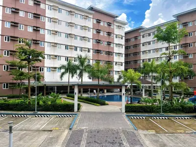 a large apartment building with a courtyard and trees at Elim Escape Staycation in Trece Martires