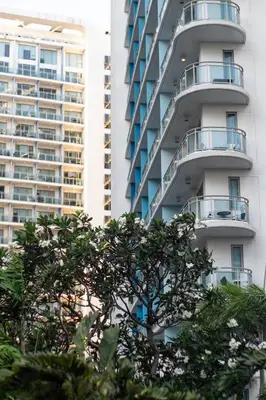 a tall white building with a tree in front of it at Azure Boracay Tower 1BR in Manila