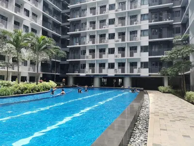 a swimming pool in front of a building at Mall of Asia Shore condo in Manila