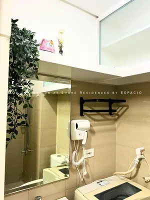 a bathroom with a mirror and a hair dryer on the wall at Ezpacio in Manila