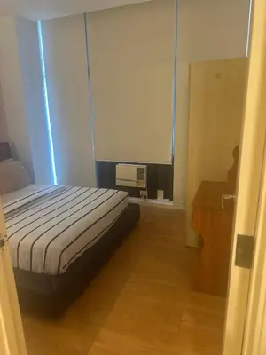 a bedroom with a bed and a desk and a window at Casa Delantera Karaoke Games Pet Friendly in Manila