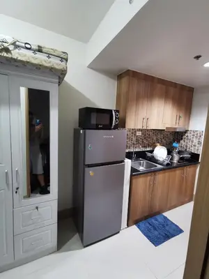 a kitchen with a refrigerator and a person taking a picture at Mall of Asia shore 3 condotel in Manila