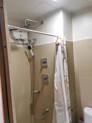 a shower in a bathroom with a shower curtain at Mall of Asia shore 3 condotel in Manila