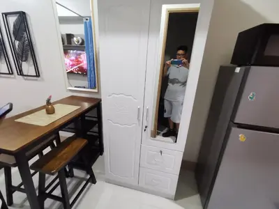 a woman taking a picture in a mirror in a kitchen at Mao condotel shore 3 Pasay in Manila