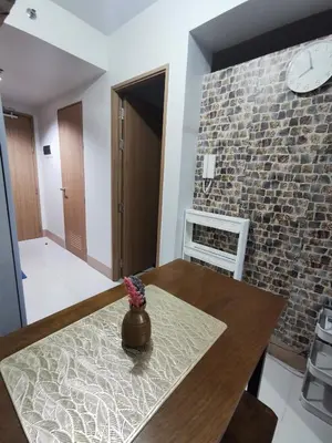 a dining room with a table and a brick wall at Mao condotel shore 3 Pasay in Manila