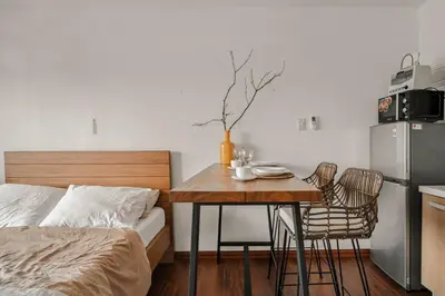 a bedroom with a bed and a table with chairs at Native studio hideaway in the heart of Poblacion, Makati in Manila