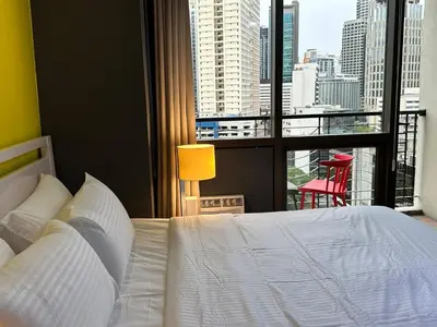 a bedroom with a white bed and a large window at Central Stay w King bed near Greenbelt 55-In TV in Manila