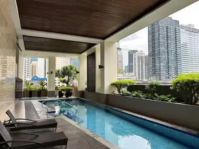 a hotel swimming pool with a view of a city at Tropical Wood Studio w Balcony Near Greenbelt Pool and Gym Access in Manila