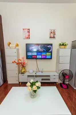 a living room with a tv on the wall at The Zen Escape 1BR Makati swim gym park cook 300MB 5940 in Manila