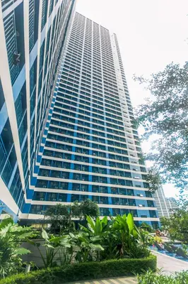 a tall building with trees in front of it at Makati Bliss Designer Stay Pool gym park Net300 makati 1767 in Manila